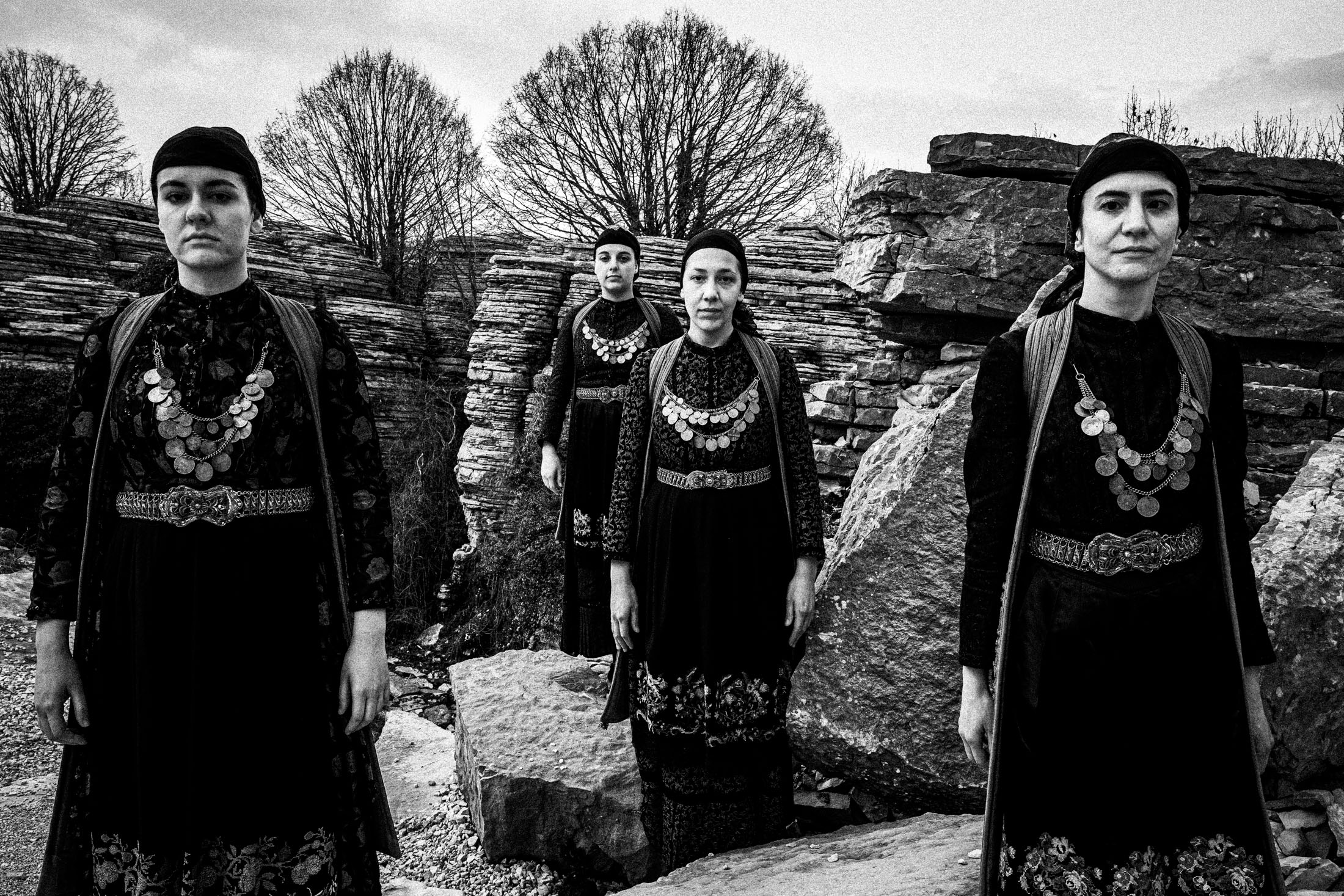 Women wearing the local costumes of Zagori in Epirus, standing in the stone forest of Monodendri