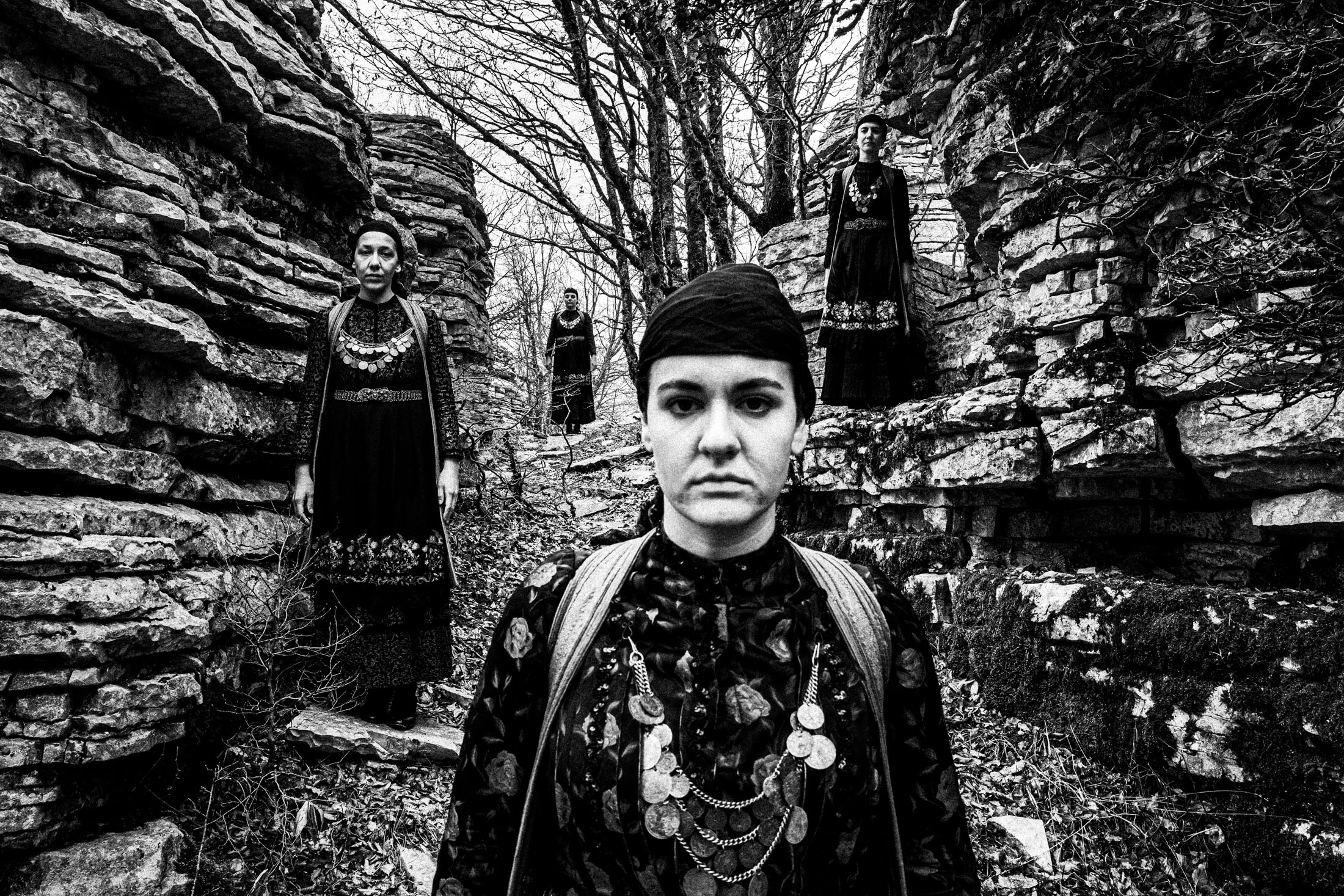 Four women wearing the local dresses of Zagori, Epirus, at the stone forest in Monodendri