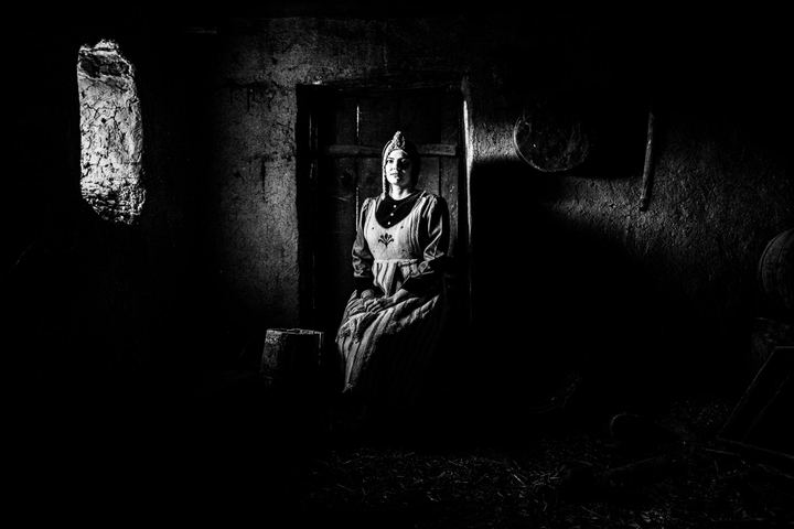 A woman wearing the rural costume of Kastoria inside a local house in the village of Lefki. Chiaroscuro portrait