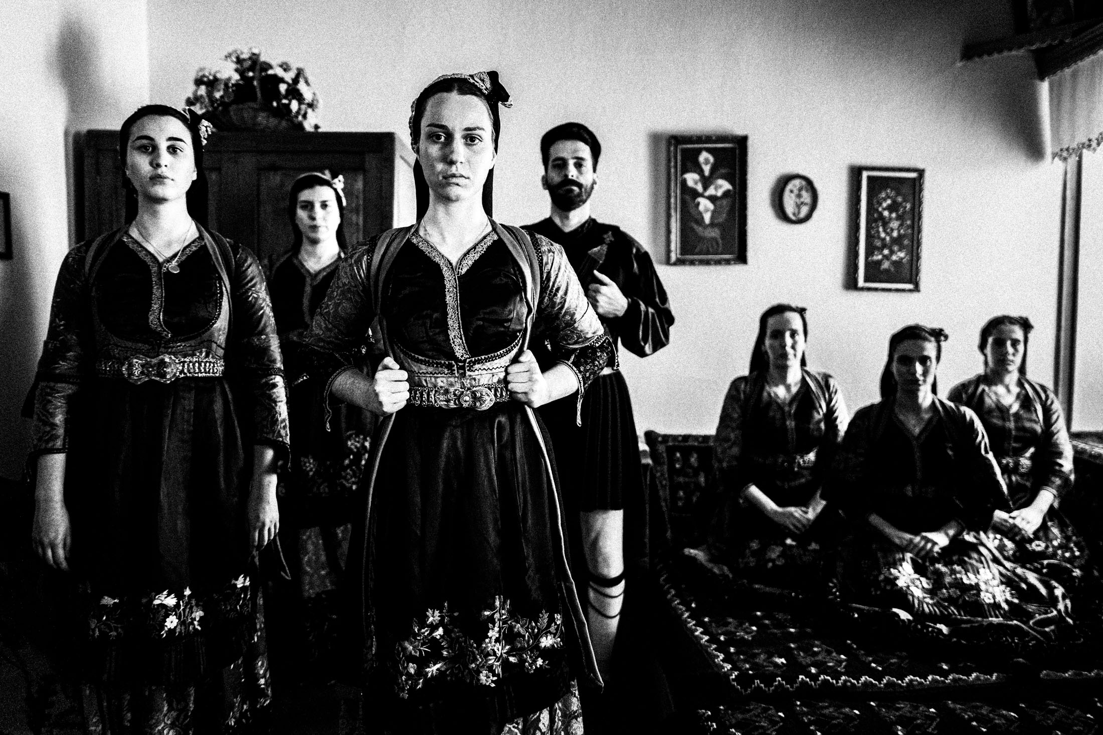 A group of people wearing the traditional costumes of Metsovo, Epirus, inside a local house.