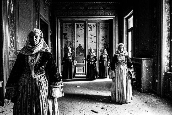 Five women wearingn the urban dresses of Spetses inside the local Anargyros manion