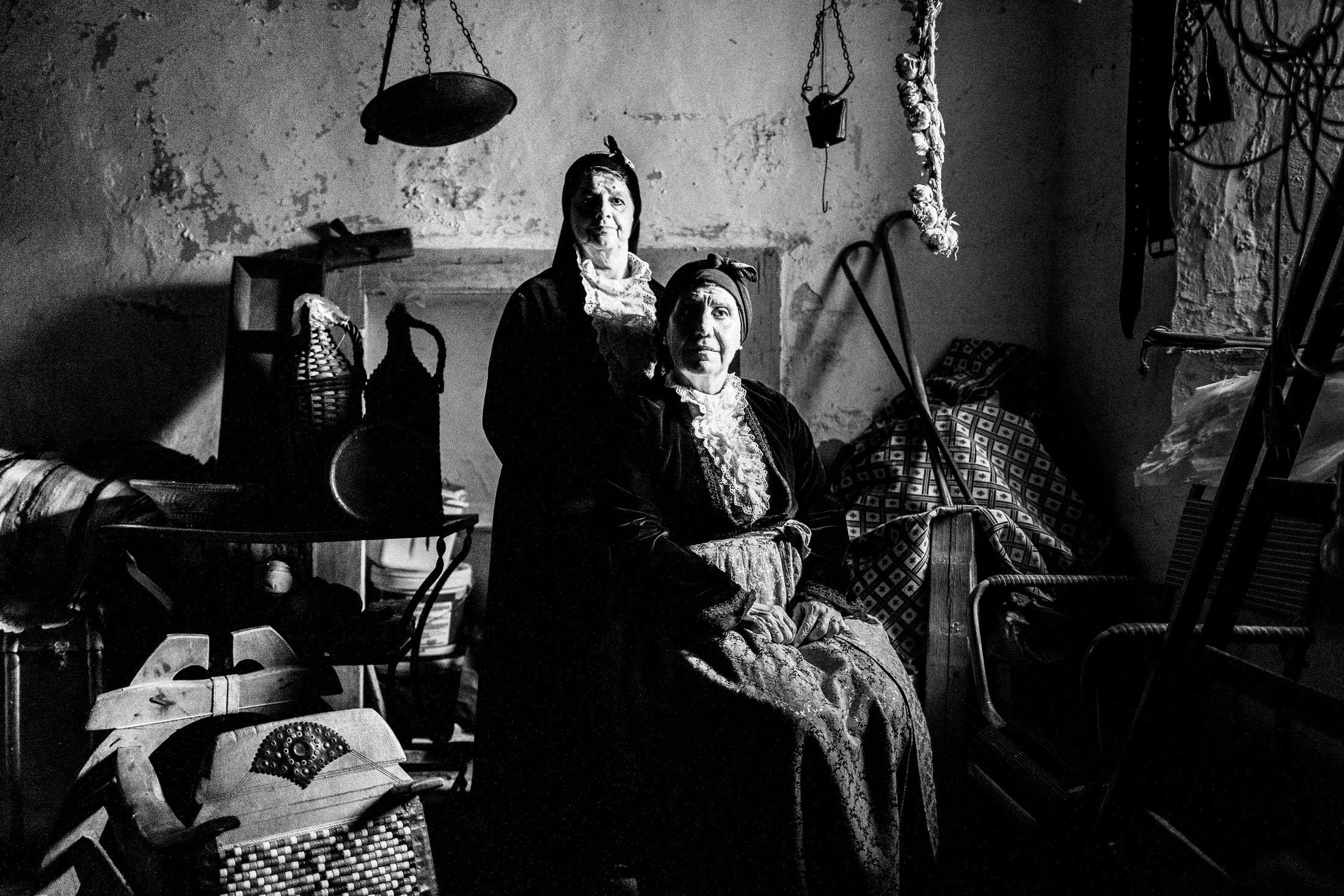 Two women wearing the urban dresses of Pelion inside a warehouse in Portaria