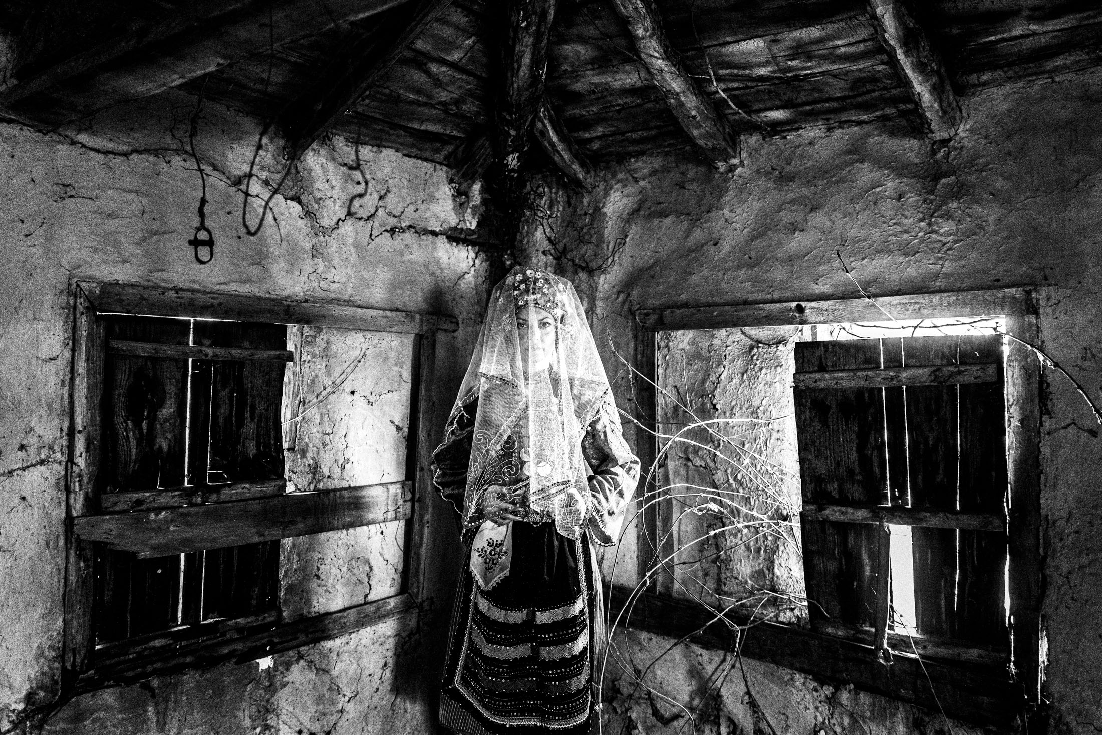 A veiled woman wearing the local bridal dress of Metaxades, inside a local house. Evros, Thrace