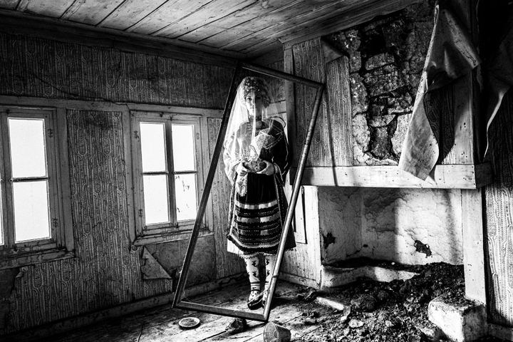 A veiled woman wearing the local bridal dress of Metaxades, inside a local house. Evros, Thrace