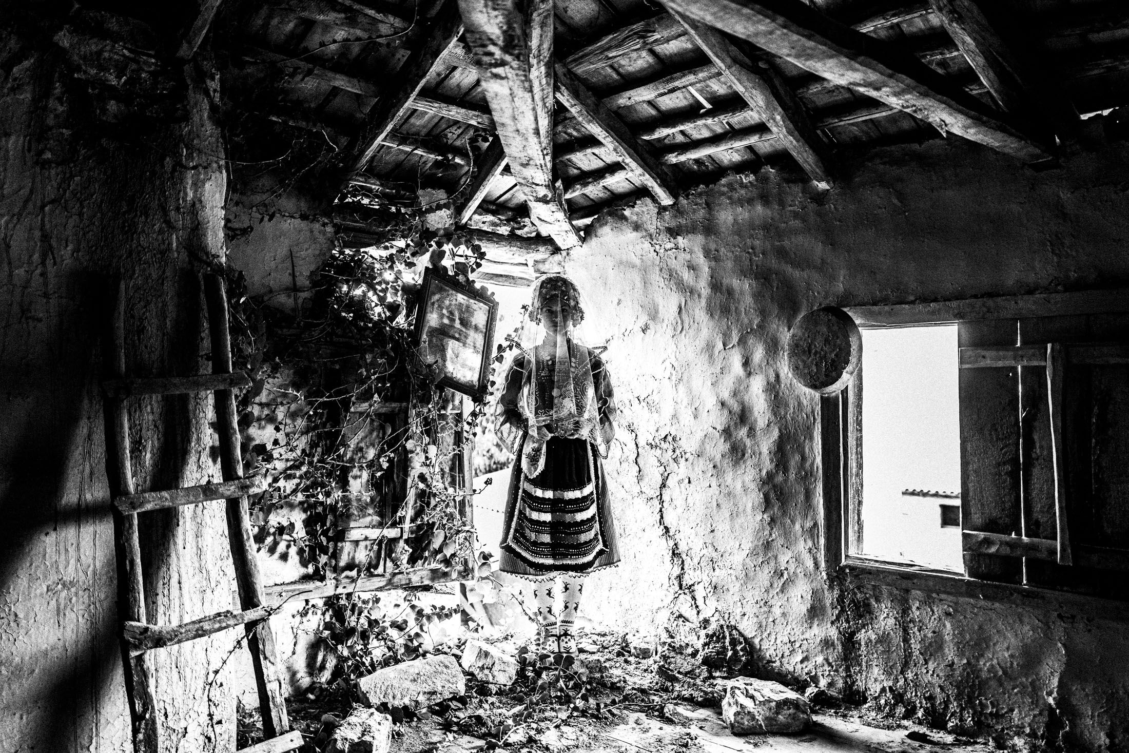 A veiled woman wearing the local bridal dress inside a ruined local house in Metaxades.
