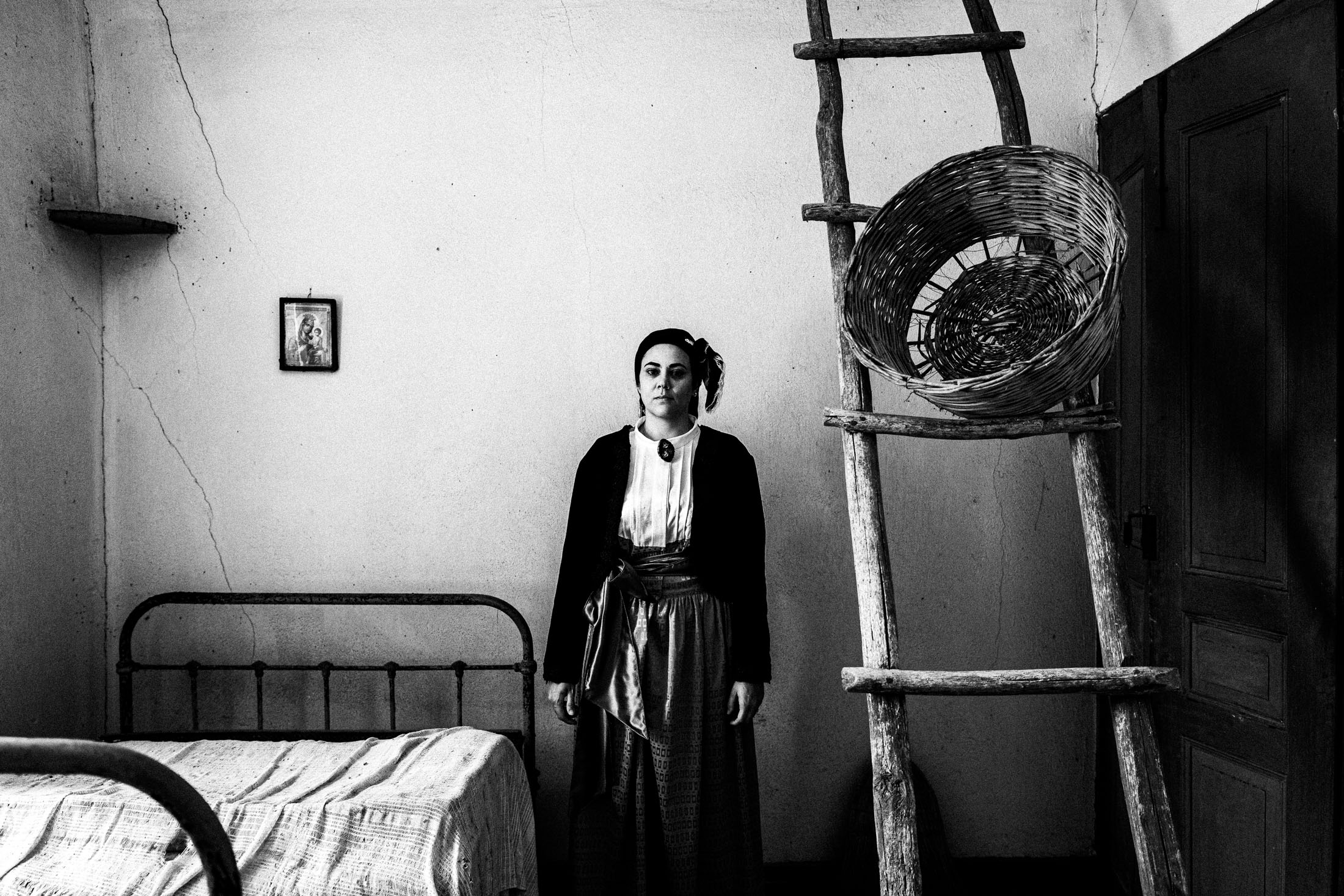Woman wearing the urban dress of Pelion, inside a house in Pinakates