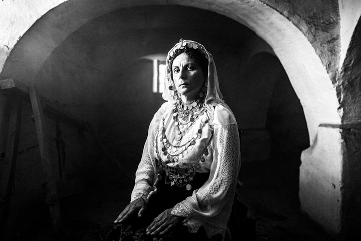 A woman wearing the local costume of Agia Anna, Euboea, inside an old local basement