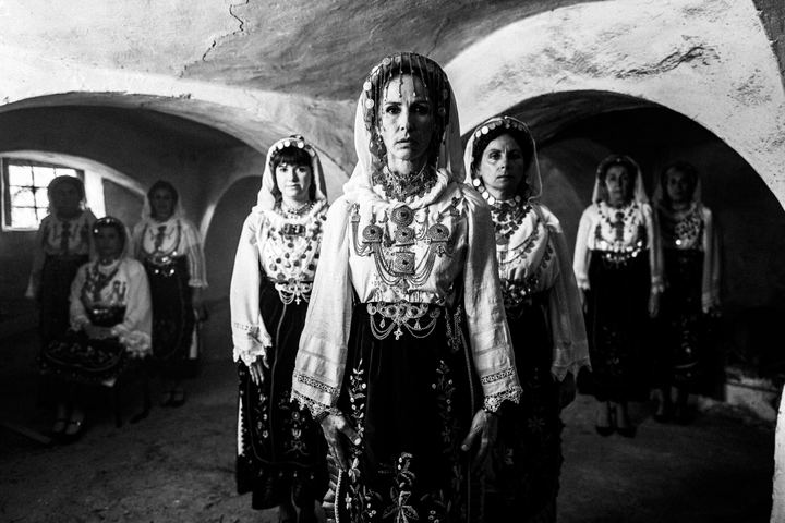 A group of women wearing the local costumes of Agia Anna, Euboea, inside an old local basement
