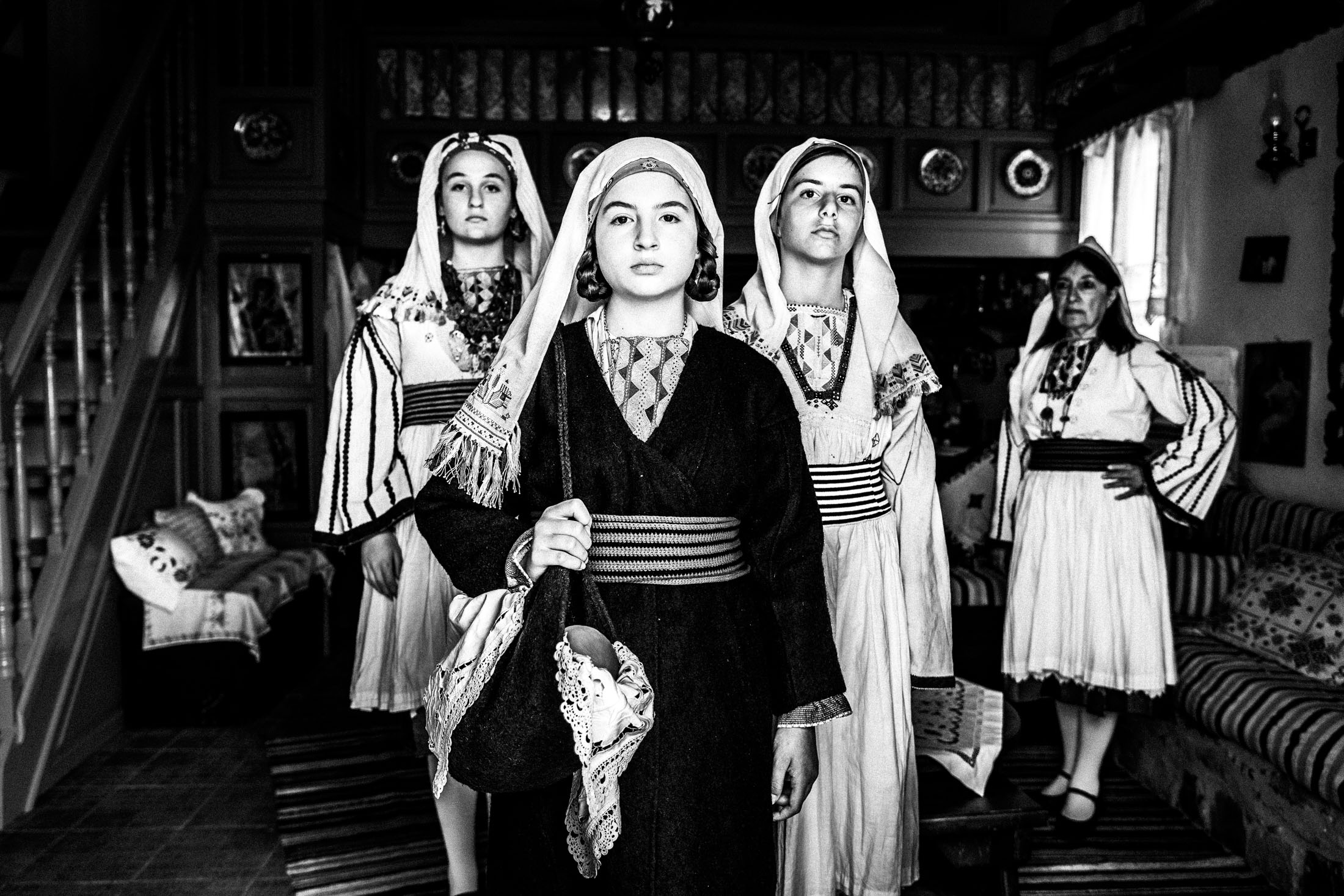 Women wearing the local costumes of Tilos, standing inside a local house