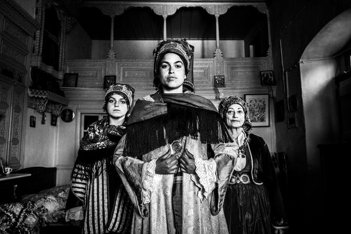 Women wearing the local costumes of Symi, inside a local house of the island