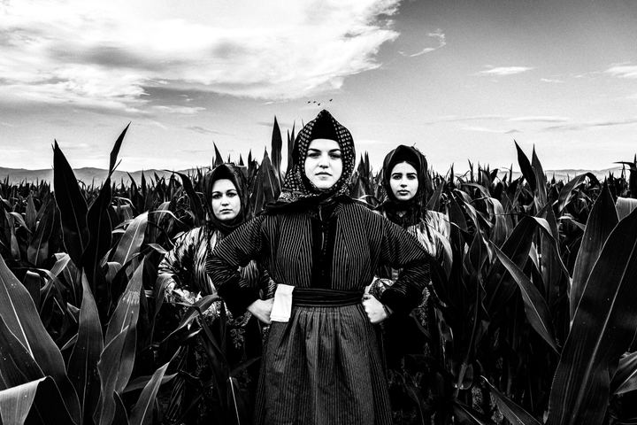 Three women wearing the local costumes of Stefanovikio in Thessaly, standing in a local field