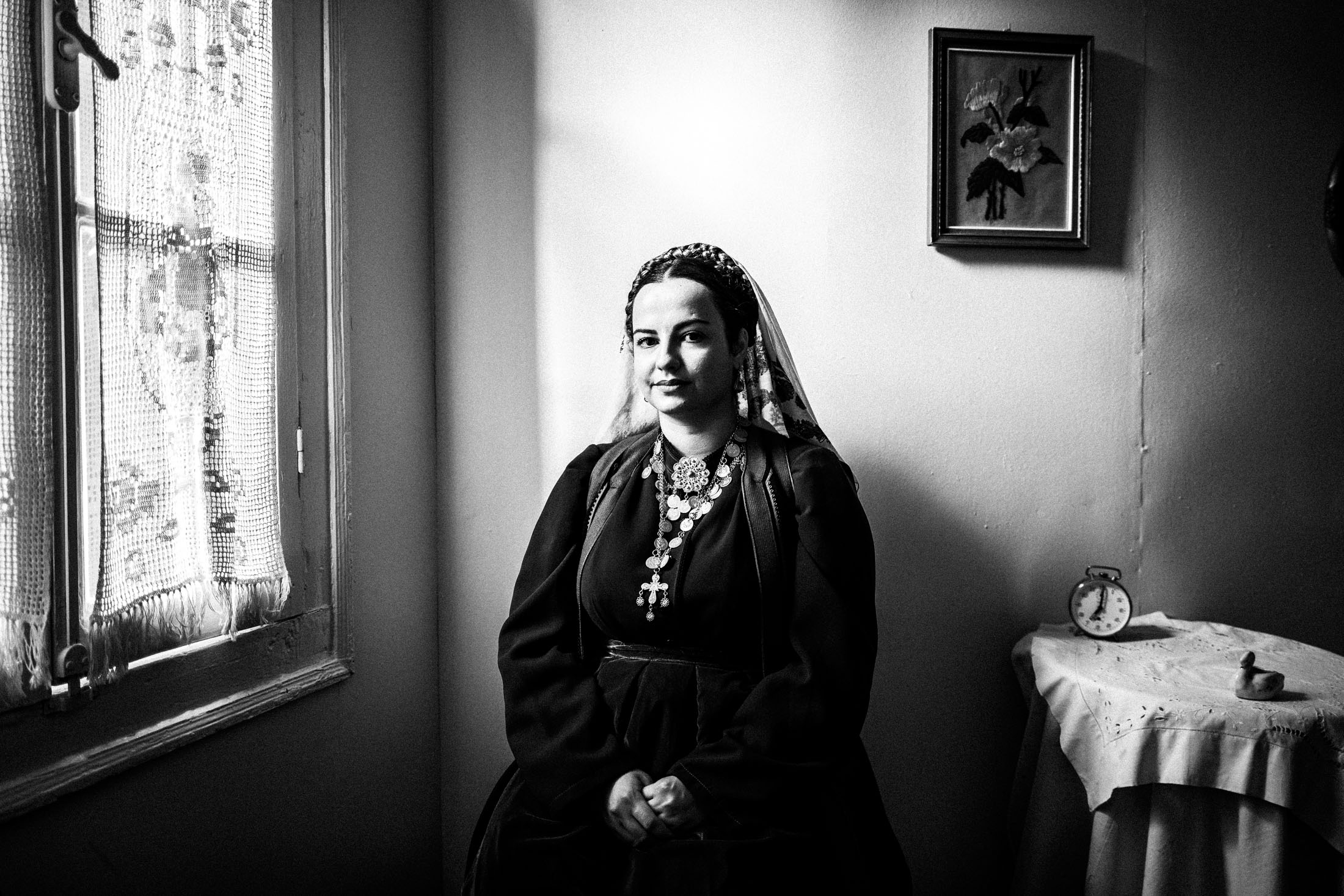 A woman wearing the local dress of Platanos, Nafpaktia, inside a local house by the window