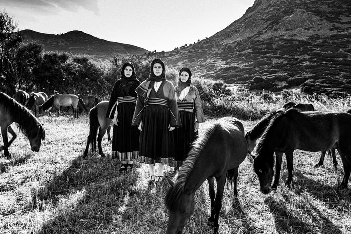 Women wearing the local costumes of Skyros island, standing by the dwarf horses of the island at a local field