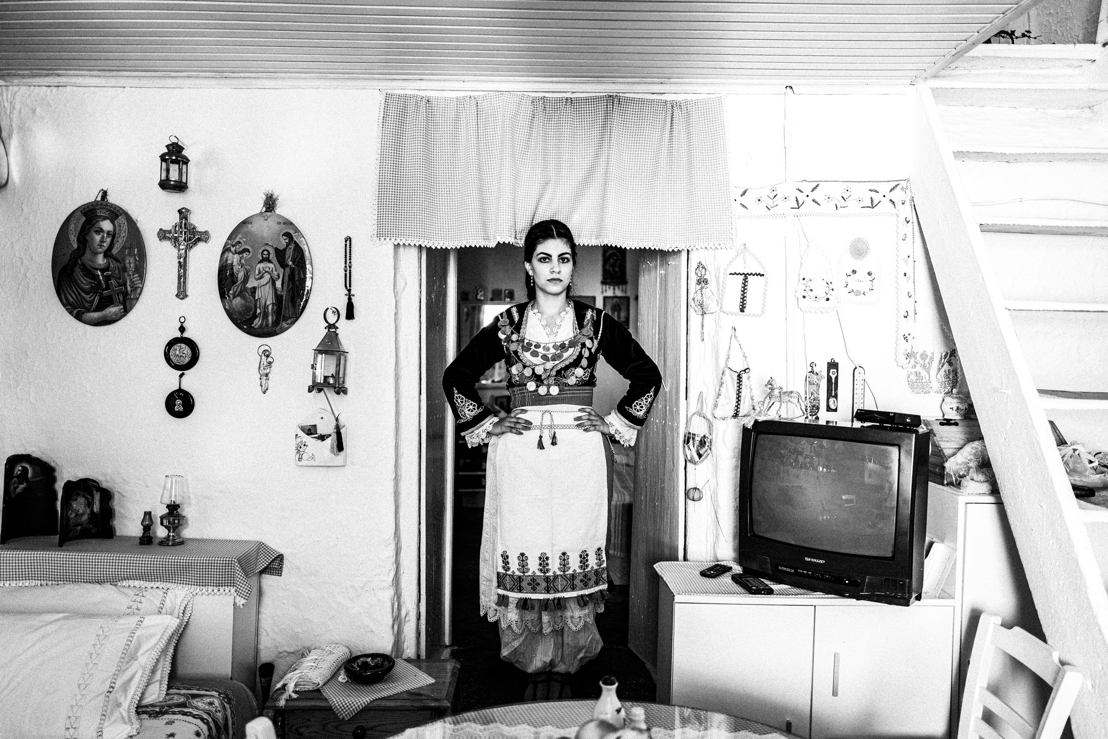 A woman wearing the local costume of Anogia, Sartza in Rethymnon Crete, inside a local traditional house