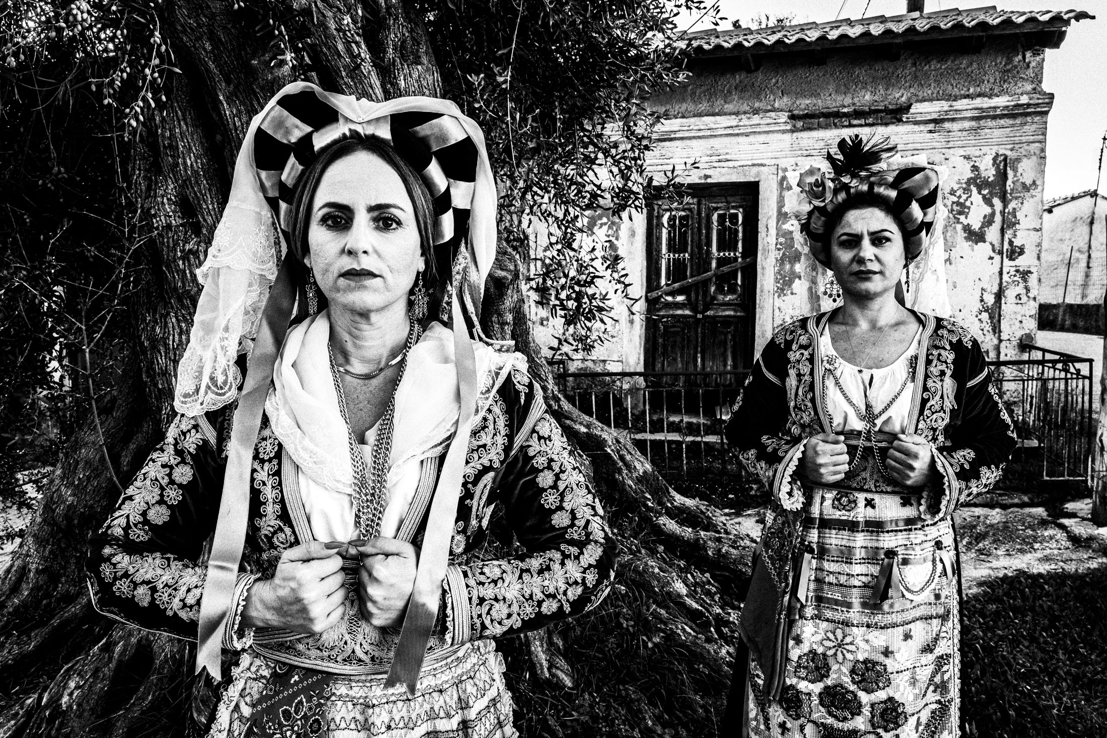Two womenn wearing the costumes of Southern Corfu posing outside a house in the village of Korakades.