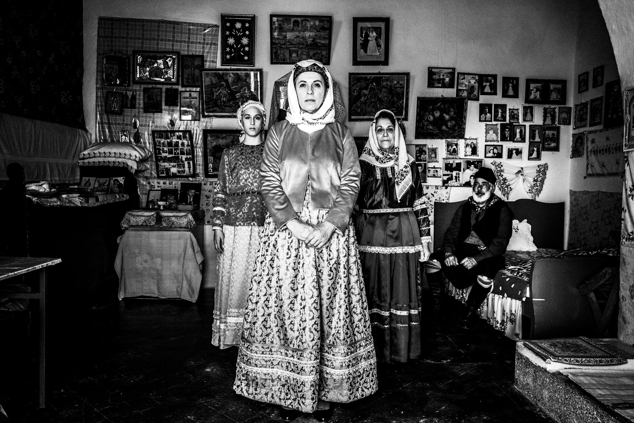 Women wearing the local costumes of Afantou in Rhodes. standing in an arrow formation inside a local house