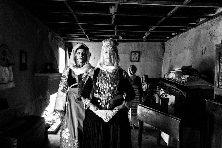 Women wearing the local costumes of Megara, Attica, posing inside a local abandoned house