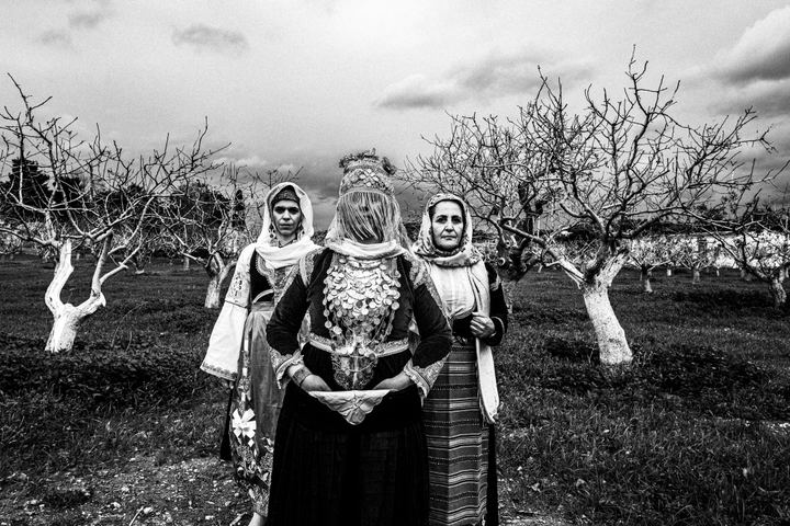 Women wearing the local costumes of Megara, Attica, posing inside a local abandoned house