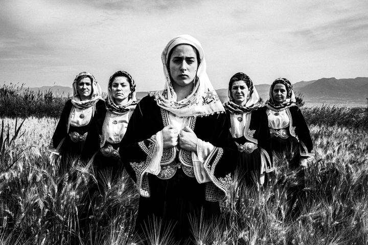 Women wearing the costume of Kymi, Euboea, standing in a local field