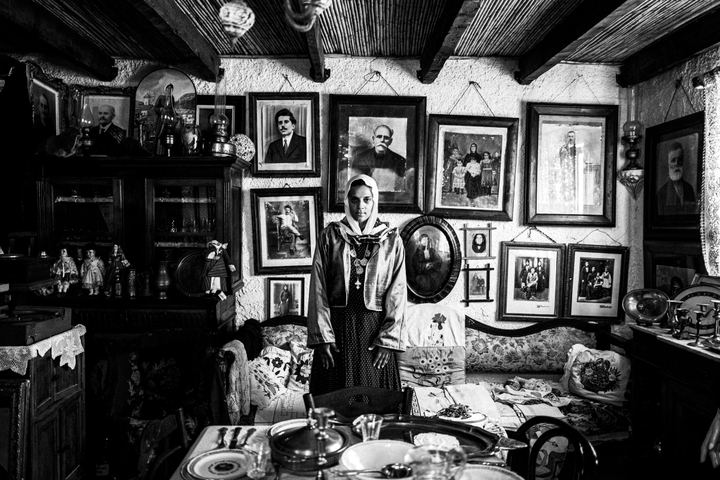 A woman dressed in the traditional costume of Kalymnos, standing inside a local folklore museum.
