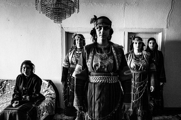 Women wearing the local costumes of Drymos in Thessaloniki, posing inside a local hosue