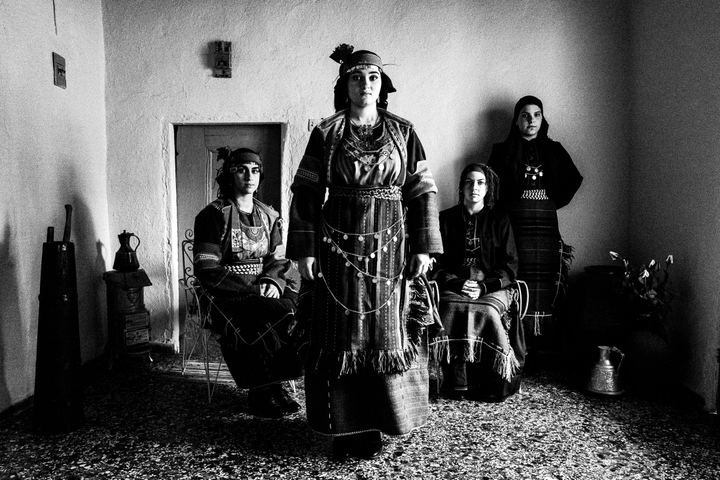 Four women in the local costumes of Drymos in Thessaloniki, inside a local house.