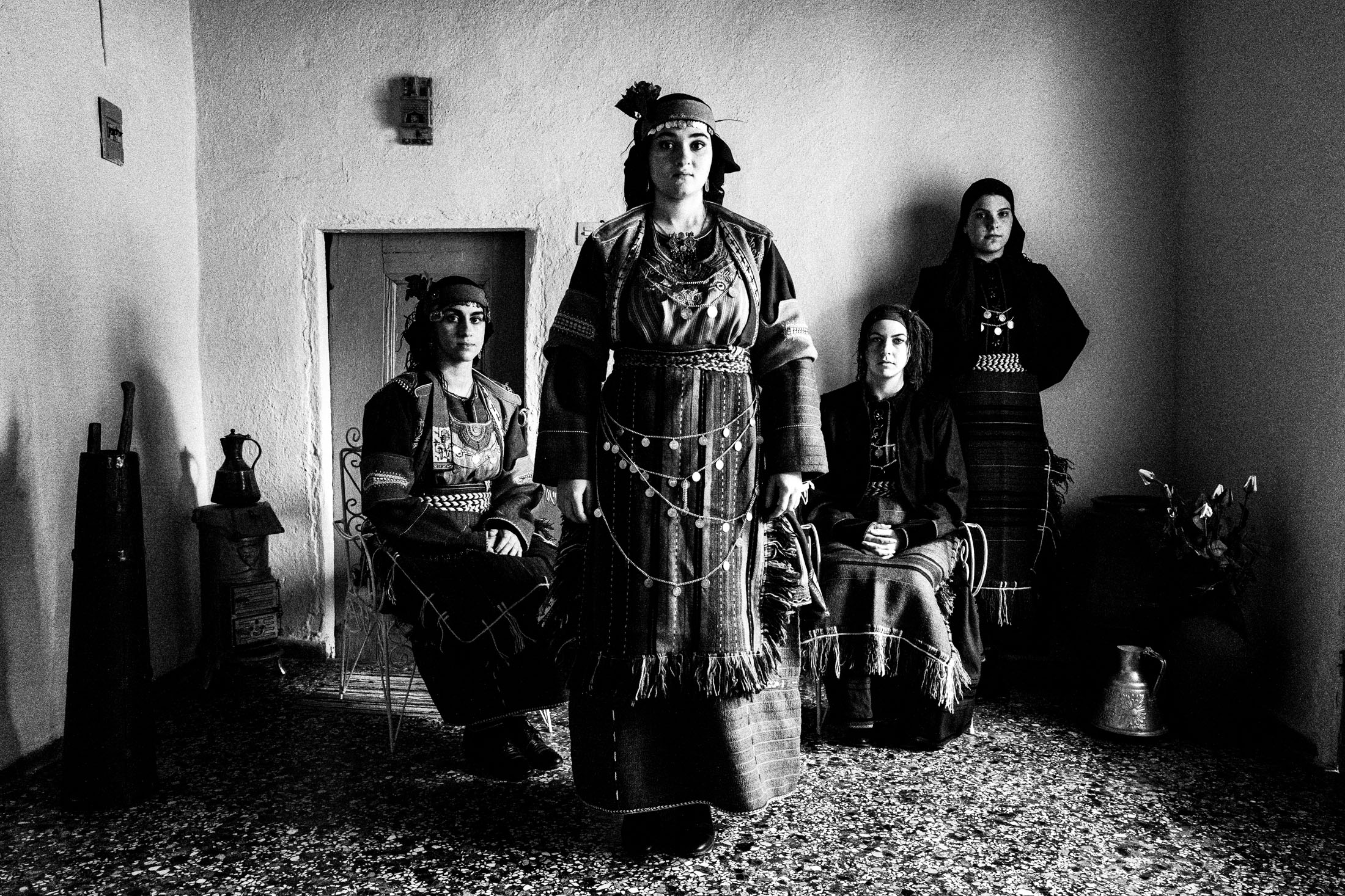 Four women in the local costumes of Drymos in Thessaloniki, inside a local house.