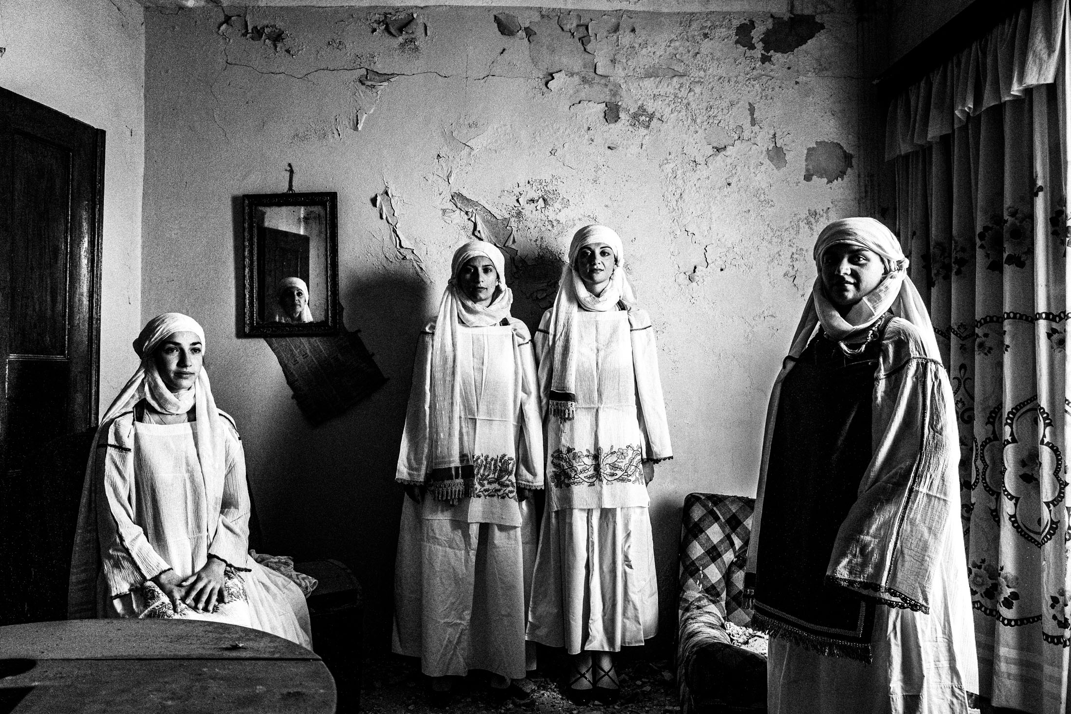 Women wearing the local costumes of Kallimasia, standing inside a local house
