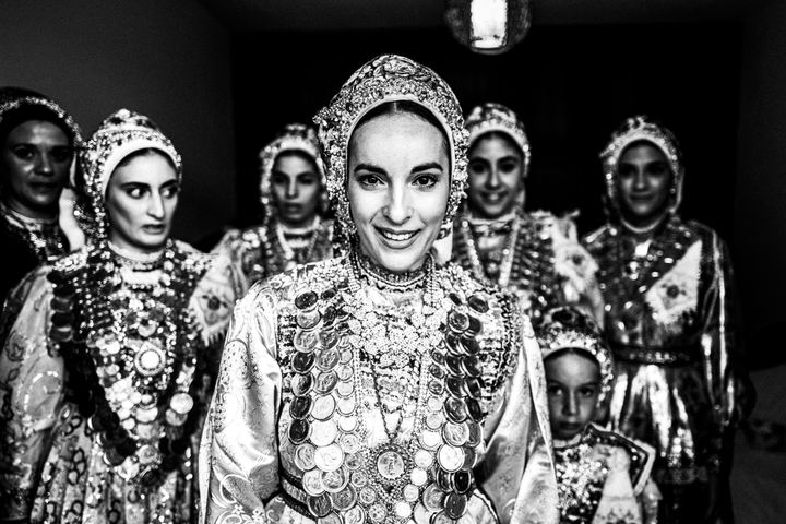 A woman in the traditional dress of Olympos standing inside a family home.