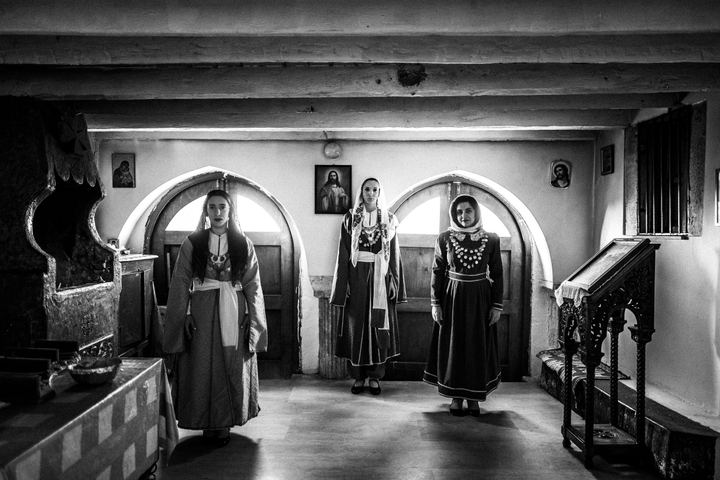 Three women in the traditional dresses of Kos, standing inside the church of St. Dimitrios in Chaichotes, Kos