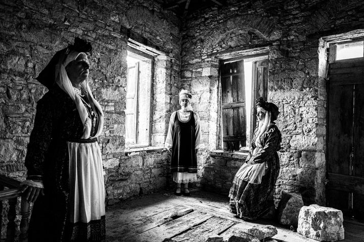 Women wearing the local costumes of Neochori, inside a local building