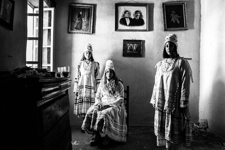 Women wearing the local costumes of Thymiana, inside a local house