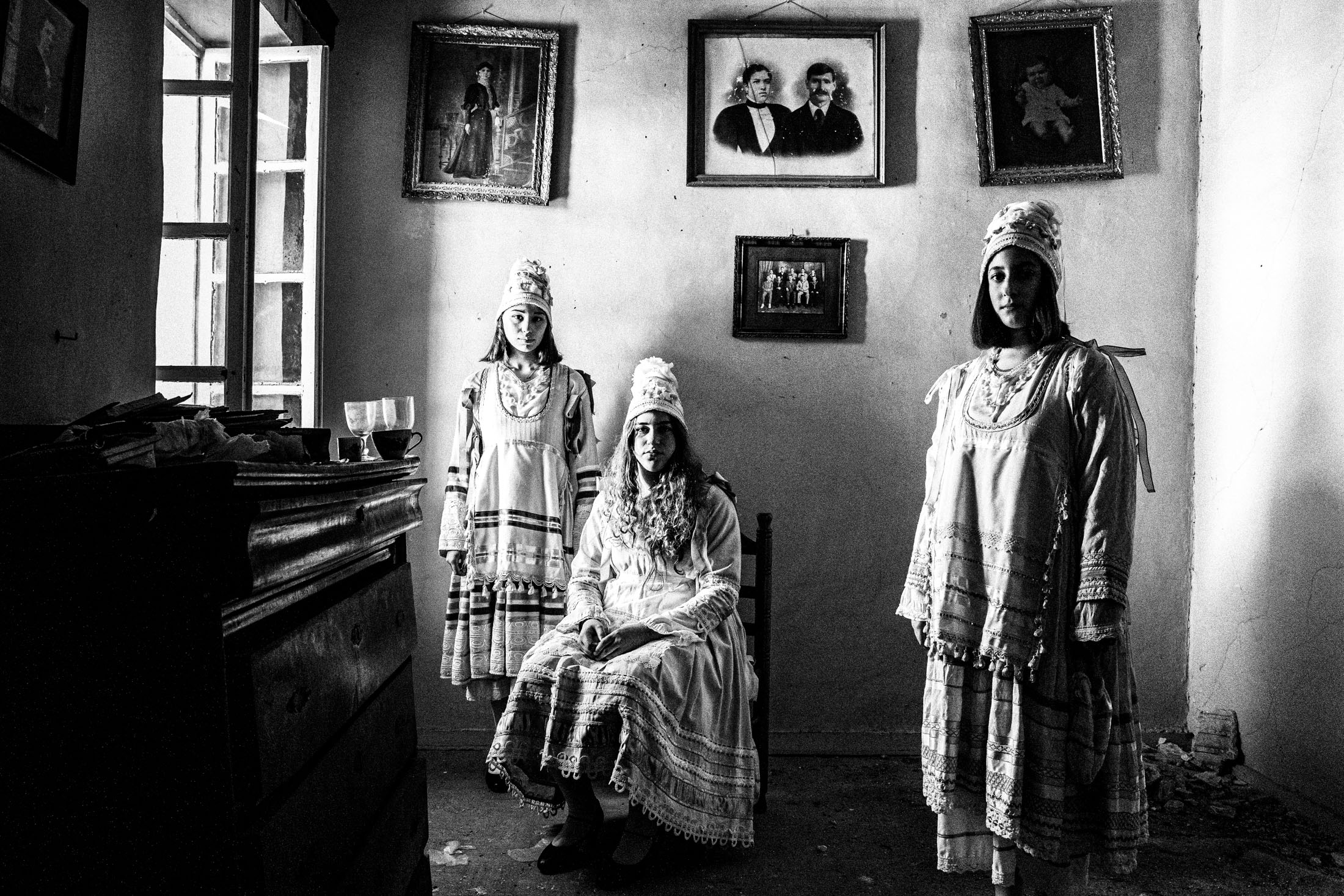 Women wearing the local costumes of Thymiana, inside a local house