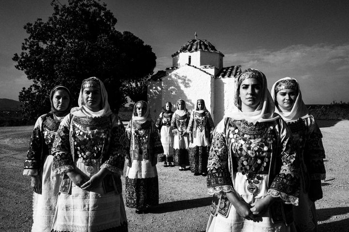Women wearing the costumes of Markopoulo, Attica standing outside a local church