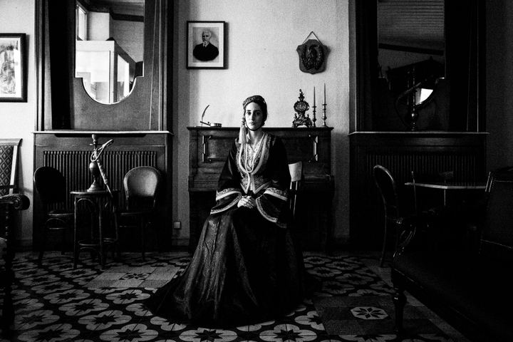 A woman wearing the Amalia traditional urban costume, inside a cafe in Tripolis, Peloponnese