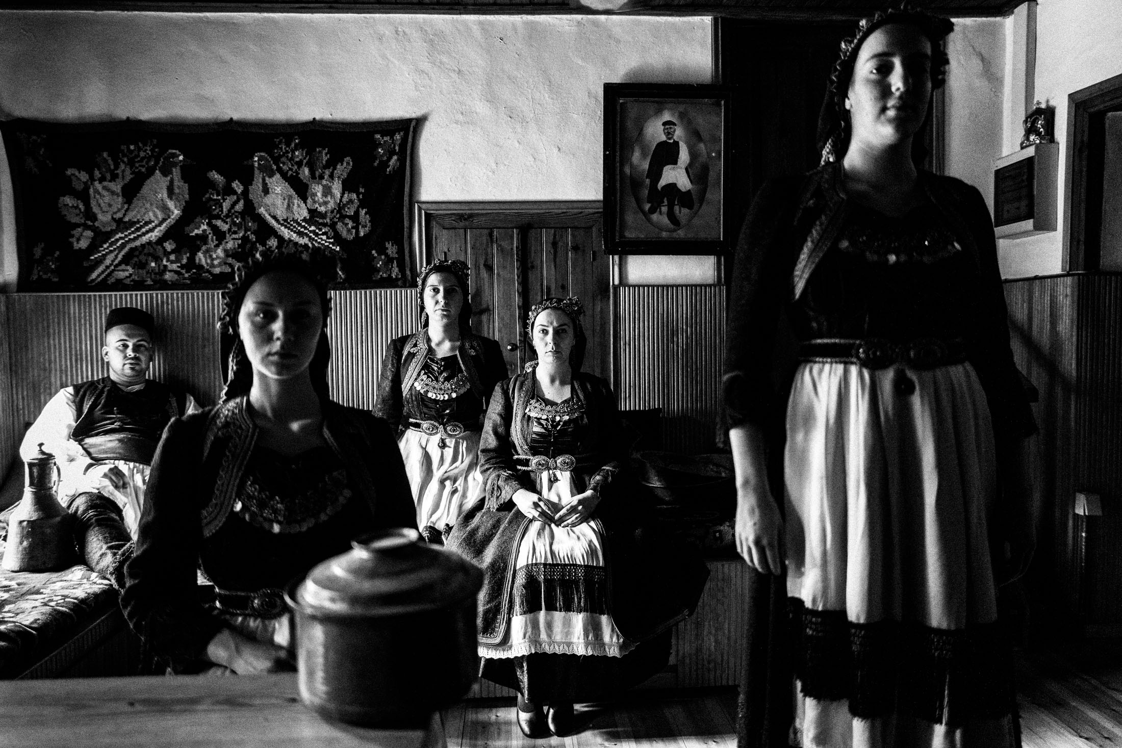 A group of people wearing the local costumes of Vovoussa in Zagori, Epirus, inside a local house