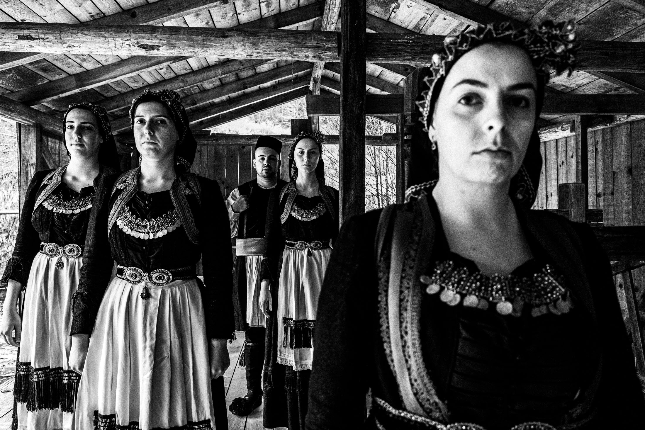 A group of people wearing the local costumes of Vovoussa in Zagori, Epirus, inside a local house