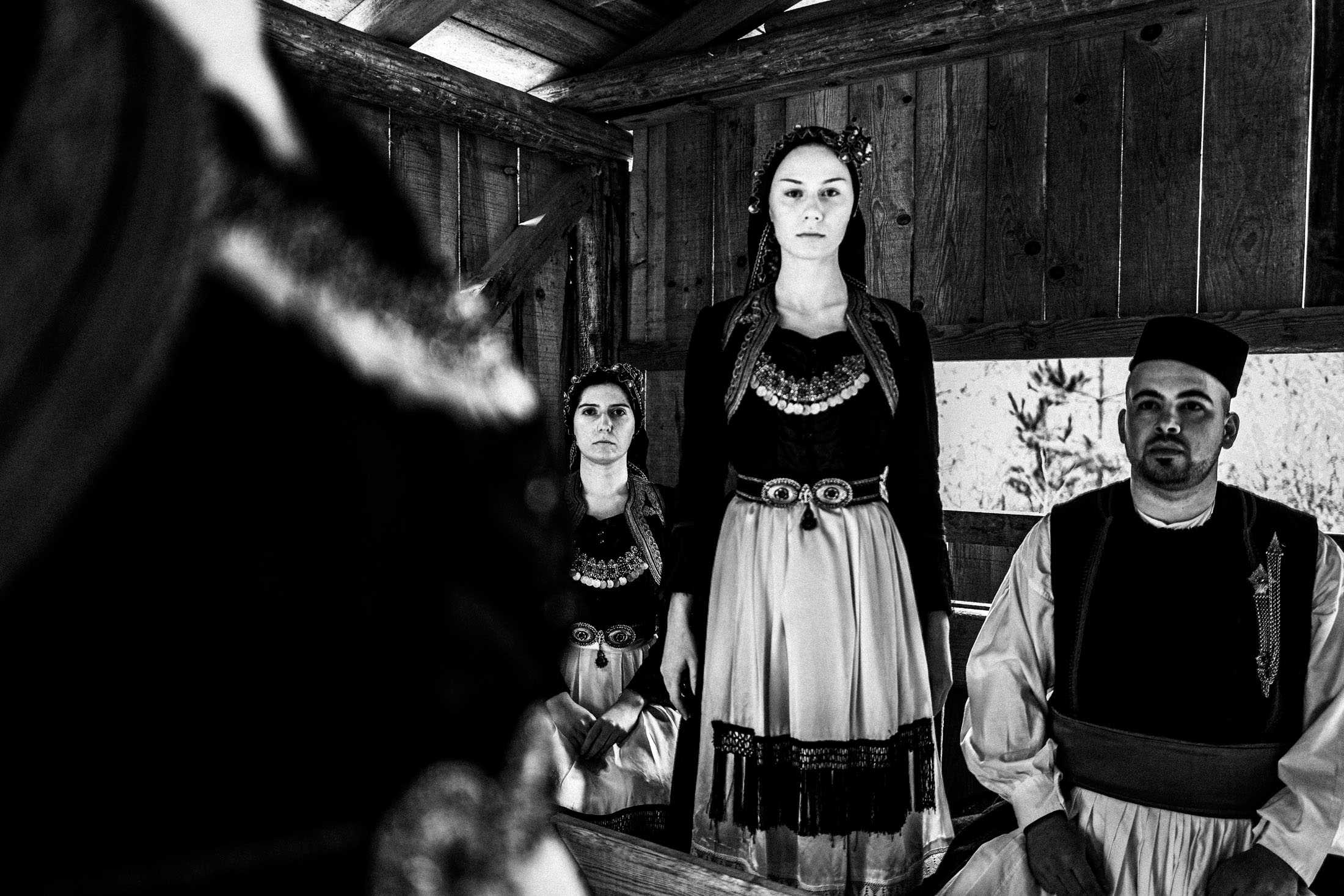 A group of people wearing the local costumes of Vovoussa in Zagori, Epirus, inside a local house