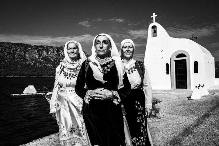Three women wearing the local costumes of Perachora, Corinth, by a local church