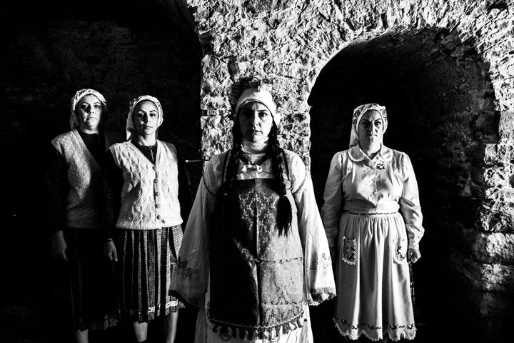 Four women inside an old local home at Mesta, Chios, wearing the local costumes.