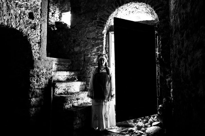 A woman inside an old local home at Mesta, Chios, wearing the local costumes.