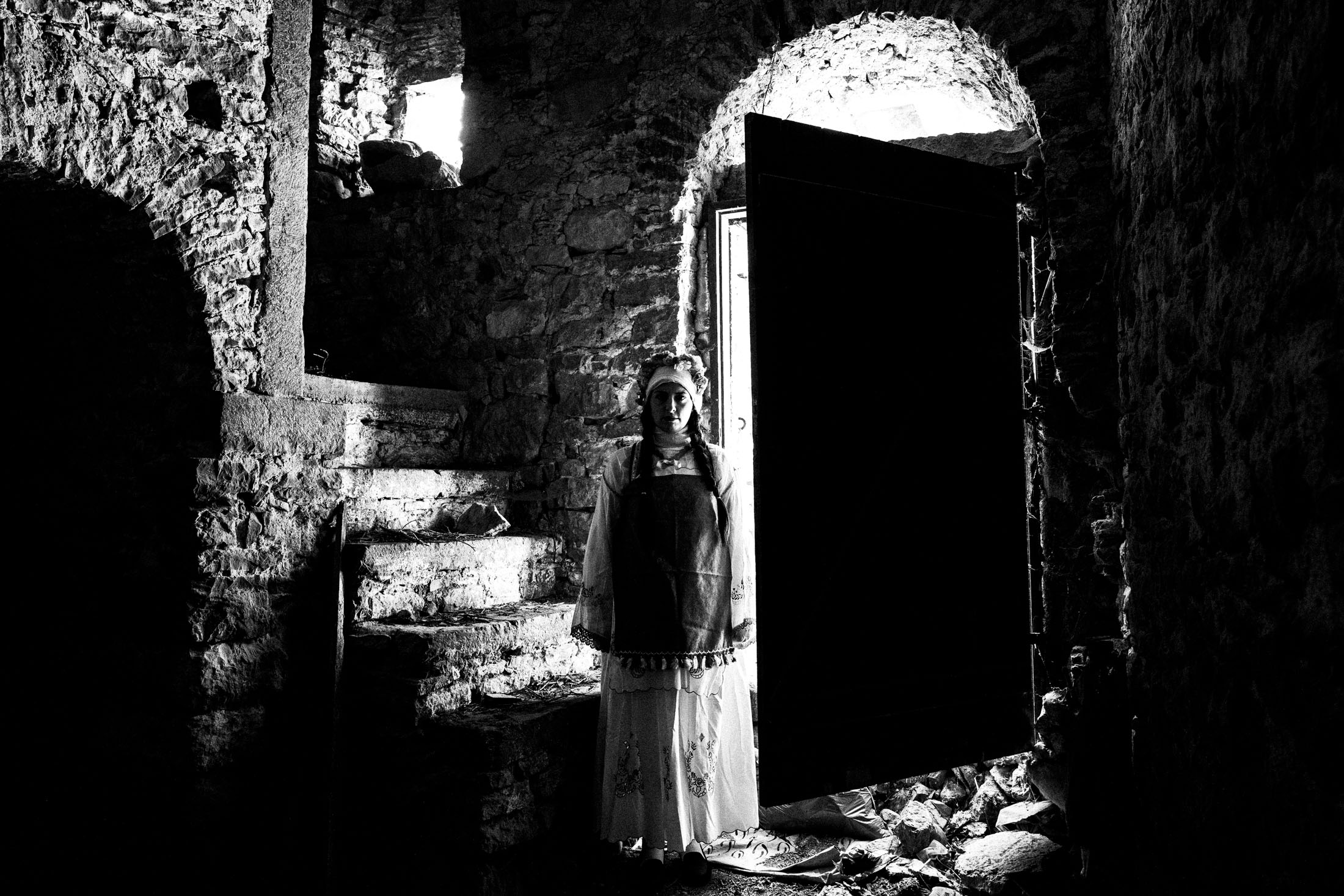 A woman inside an old local home at Mesta, Chios, wearing the local costumes.