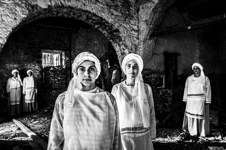 Women wearing the local dresses of Ververato inside an old mill