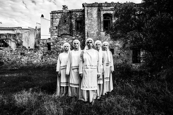 Five women standing in formation at a backyard, wearing the lolcal costumes of Ververato