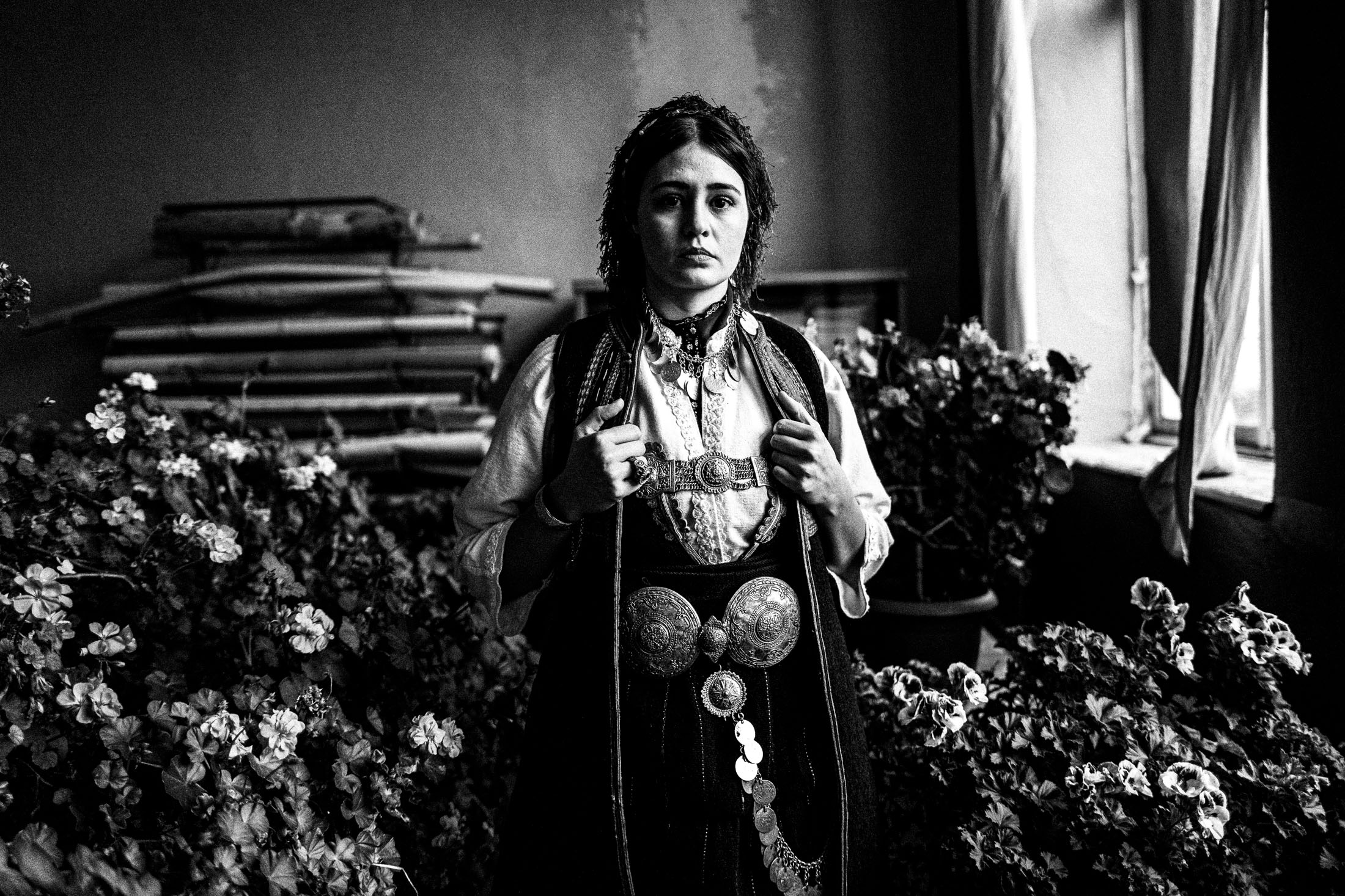 A woman wearing the local costume of Polypotamos in Florina, inside a local house among carnation flowers