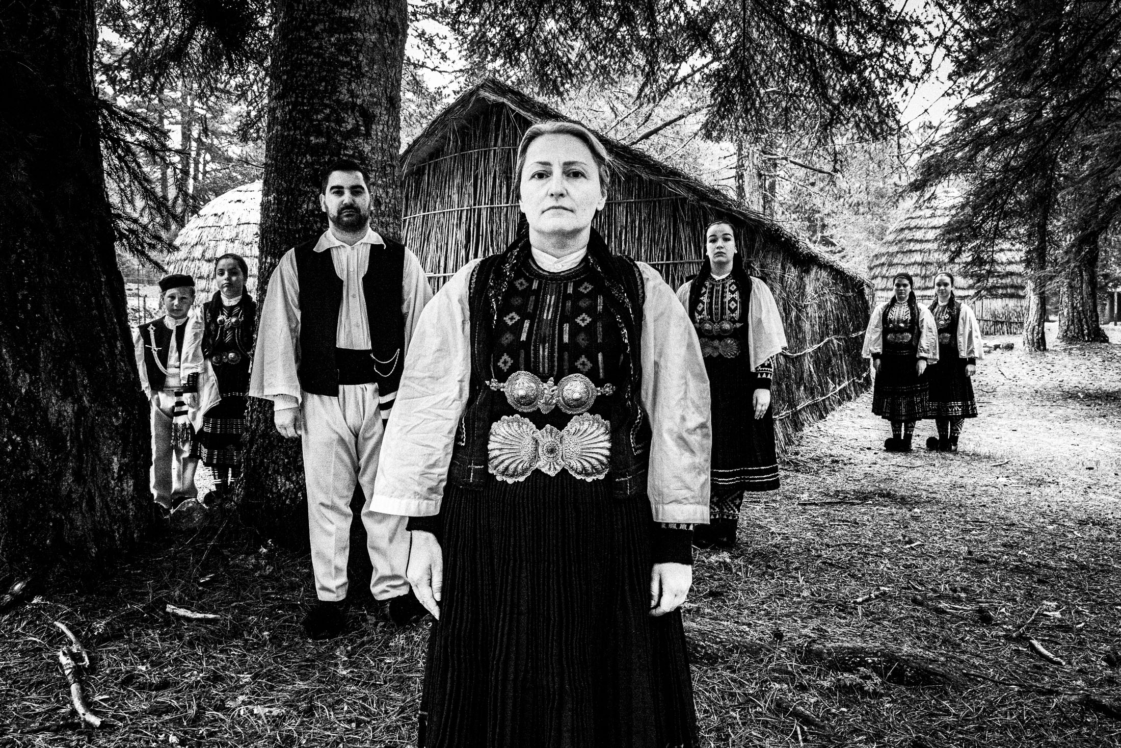 A group of people wearing the costumes of the nomadic grouop of Sarakatsani at Gyftokampos by traditional huts