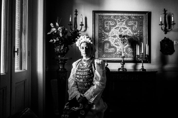 A woman wearing the local costume of Atalanti, sitting by a window inside a local house