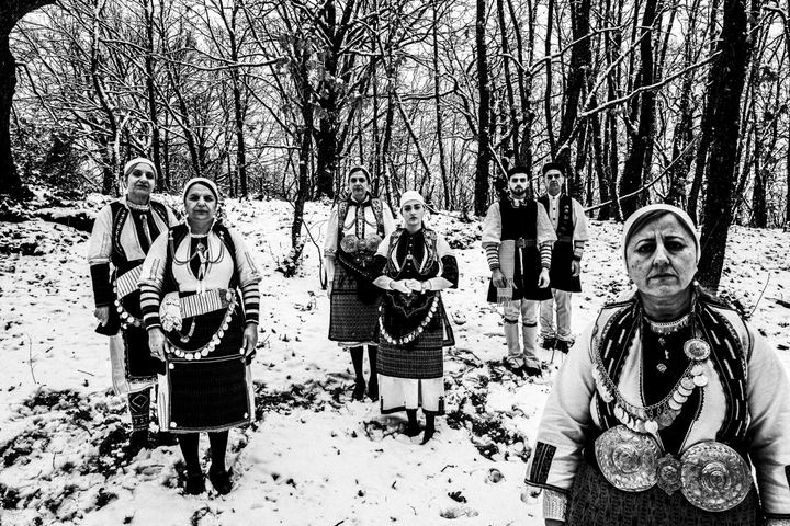 A group wearing the costumes of Kladorrachi standing in the snow at a local forest