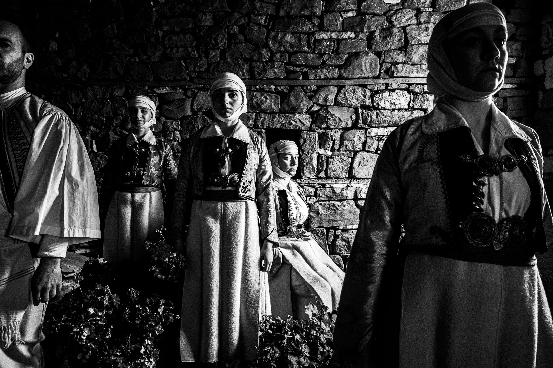 A group of people wearing the costumes of Pogoni, Epirus, inside a local house