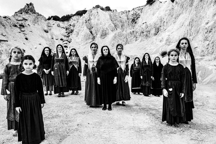 Women wearing the local costumes of Lefkada in the Ionian, standing at local white cliffs